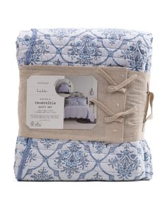 two blue and white bedspreads on top of each other, one with a pillow