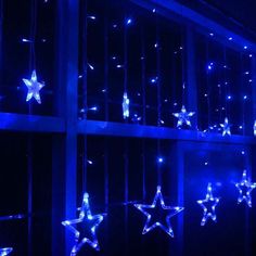 blue lights hanging from the side of a building with stars on them and an arrow pointing up