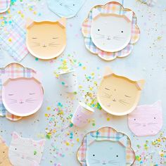 paper plates with cats on them and confetti scattered around