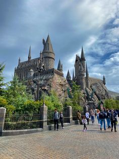 people are walking around in front of hogwarts castle