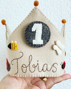 someone is holding up a felt house with the number one on it