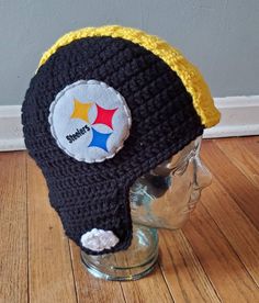 a black and yellow crocheted hat with a pittsburgh football logo on it sitting on top of a mannequin head