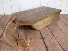 a wooden bench sitting on top of a wooden floor next to a string tied around it