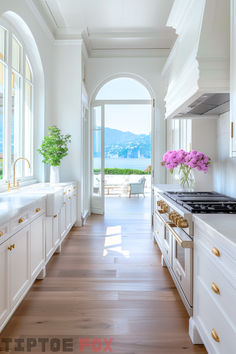 a large kitchen with white cabinets and wood flooring next to an open door leading to a balcony