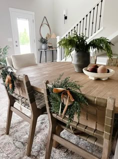 a dining room table with chairs and wreaths on it