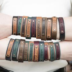 two women wearing leather bracelets with names on them