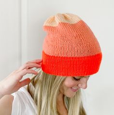 a woman wearing an orange and white knitted hat