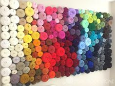 there are many different colors of yarn on the wall