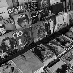 many magazines are stacked on top of each other in this black and white photo,