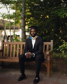 a man in a suit sitting on a wooden bench