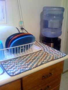 a kitchen sink with dishes in it and a water jug on the counter top next to it