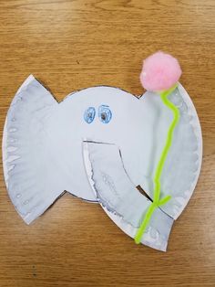 an elephant made out of paper with a flower on it's head and eyes