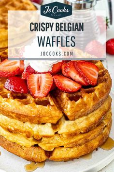 a stack of waffles with strawberries on top and the words crispy belgium waffles above it