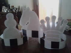 three paper crowns sitting on top of a wooden table next to a mirror in a room