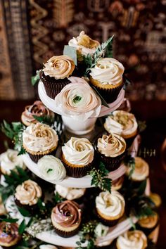 a wedding cake with cupcakes and flowers on it