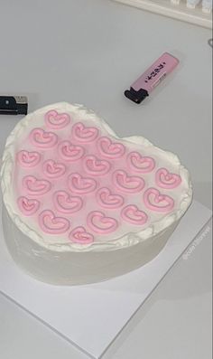 a heart shaped cake sitting on top of a table next to a usb cable and battery