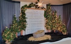 three christmas trees are on display in front of a sheet music score and string lights