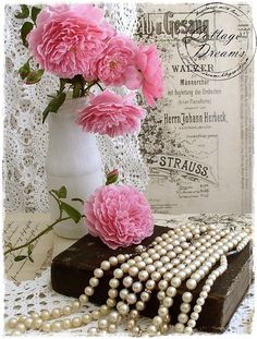 pink carnations in a vase with pearls