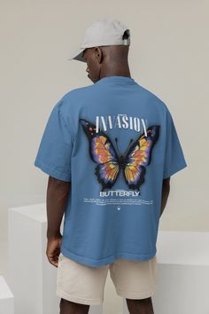 Introducing our Butterfly T-Shirt. Crafted from high-quality heavy cotton, this shirt embodies both comfort and style. The colorful butterfly back print adds a whimsical touch, perfect for those who love streetwear with a nature-inspired twist. Embrace your unique style and stand out with this eye-catching insect shirt that merges street fashion with the beauty of butterflies. 🌱 SAVING THE TREES WITH EACH PURCHASE 🌱 With every purchase you make, we pledge to plant a tree. Your support not only benefits the environment but also transforms lives. Join us in planting trees and making a positive impact. We appreciate your contribution! ✨ Quality ✨ Our clothing boasts 100% premium combed cotton, woven in a 32-count plain weave that's pre-shrunk for durability. Its heavyweight quality ensures Blue Top With Butterfly Print And Crew Neck, Blue Crew Neck Top With Butterfly Print, Blue Butterfly Print Short Sleeve T-shirt, Blue Short Sleeve T-shirt With Butterfly Print, Short Sleeve Cotton Tops With Butterfly Print, Summer Cotton Shirt With Back Print, Cotton Tops With Butterfly Print And Short Sleeves, Cotton Shirt With Back Print For Summer, Cotton Graphic Tee With Back Print