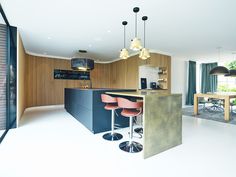 a modern kitchen with bar stools next to an island in the middle of the room