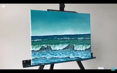 an easel is holding up a painting of waves