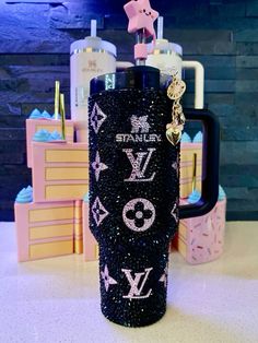 the black louis vuitton glitter tumbler is next to other items on display