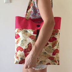 a woman holding a red and white bag