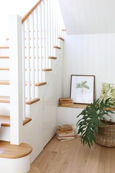 there is a plant in the basket on the floor next to some books and stairs