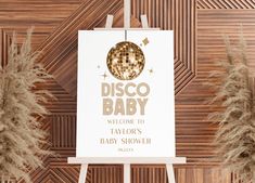 a disco baby welcome sign in front of some pamolite plants and wood paneling