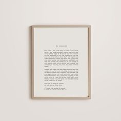 a framed print with an old fashioned typewriter's handwriting on it, in front of a white wall