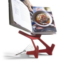 an open cookbook on a stand with a spatula