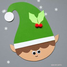 an ornament with a green elf's hat and holly berry on it