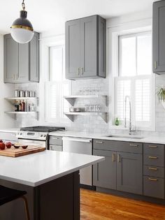 a kitchen with gray cabinets and white counter tops