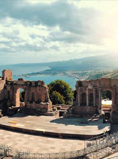 the ruins of an ancient roman theatre with water and mountains in the background