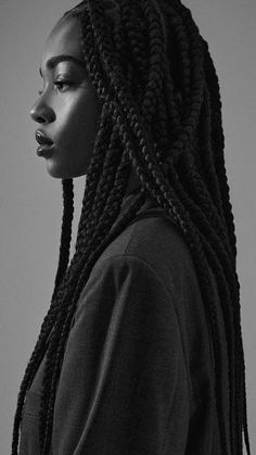 a black and white photo of a woman with long braids