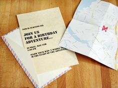 two envelopes are sitting next to each other on a table with the words join us for a birthday adventure