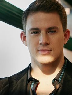 a young man wearing a black shirt and tie