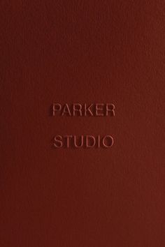 the parker studio logo is shown on a red leather cover with white lettering that reads parker studio