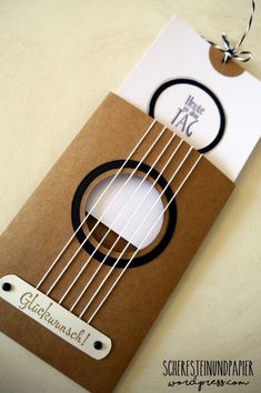 a note card with an acoustic design on the front and back of it, attached to a string