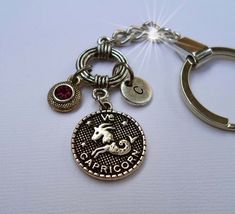 a close up of a keychain with a horse and zodiac charms on it