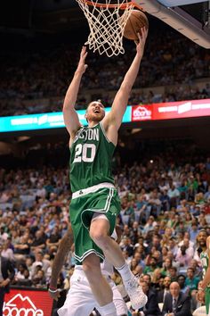 a basketball player is jumping up to dunk the ball in front of an audience