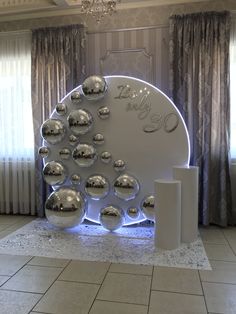 a large display in the middle of a room with silver balls on it and a chandelier hanging from the ceiling