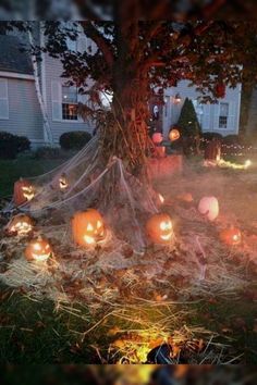 pumpkins are lit up on the ground in front of a house at halloween time