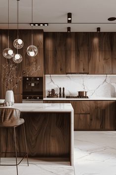 a modern kitchen with marble counter tops and wooden cabinetry, along with bar stools