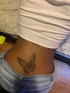 a woman with a butterfly tattoo on her lower back