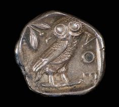 a silver coin with an owl on it