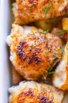 chicken thighs with potatoes and herbs in a pan