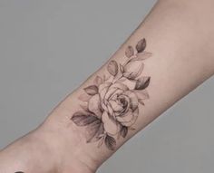 a woman's arm with a rose tattoo on it