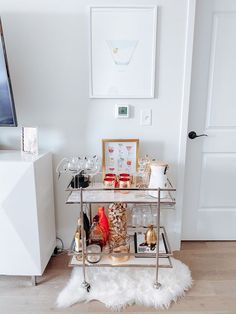 a bar cart filled with drinks on top of a hard wood floor