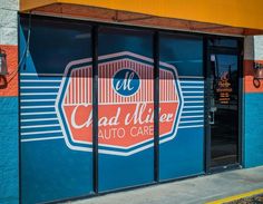 the entrance to a auto care store with blue and orange painted on it's doors